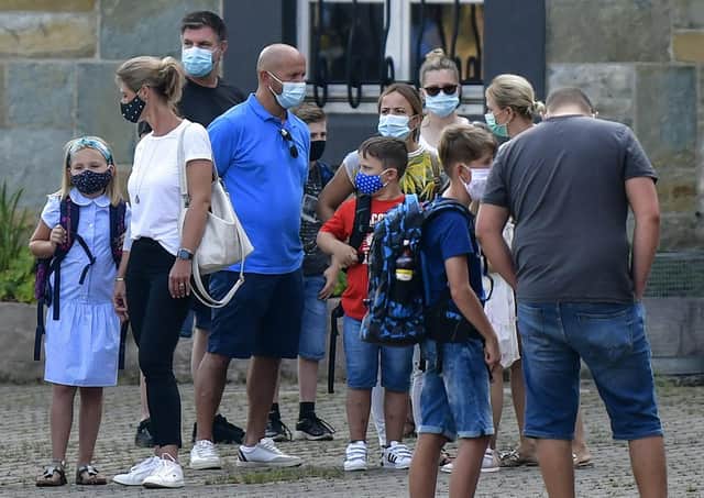 Parents have been warned not to gather with children near school gates to avoid the spread of coronavirus. Picture: AP Photo/Martin Meissner