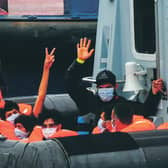 Migrants gesture as they arrive in port aboard a Border Force vessel after being intercepted while crossing the English Channel from France. Picture: Peter Summers/Getty Images