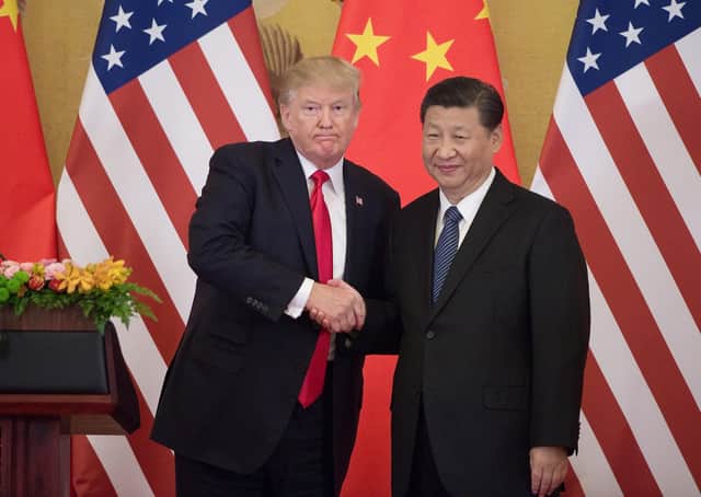 It's all smiles as Donald Trump and Xi Jingpinig shake hands, but the US and China are bitter global rivals (Picture: Nicolas Asfouri/AFP/Getty Images)