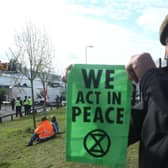 A protester holds up an Extinction Rebellion bannerat the blockade of the Newsprinters printing works t Broxbourne, Hertfordshire. Picture: PA