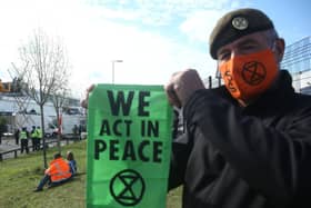 A protester holds up an Extinction Rebellion bannerat the blockade of the Newsprinters printing works t Broxbourne, Hertfordshire. Picture: PA
