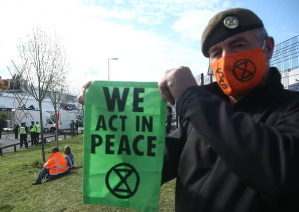 A protester holds up an Extinction Rebellion bannerat the blockade of the Newsprinters printing works t Broxbourne, Hertfordshire. Picture: PA