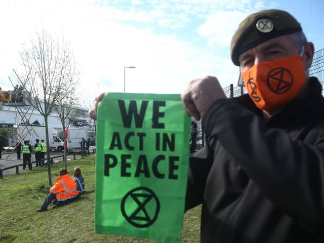 A protester holds up an Extinction Rebellion bannerat the blockade of the Newsprinters printing works t Broxbourne, Hertfordshire. Picture: PA