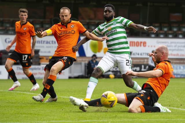 Dundee United defender Mark Connolly, grounded, slides in to tackle Celtic striker Odsonne Edouard. Picture: SNS.