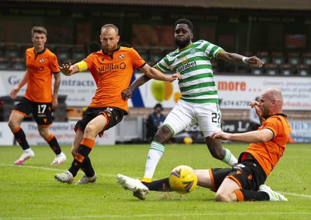 Dundee United defender Mark Connolly, grounded, slides in to tackle Celtic striker Odsonne Edouard. Picture: SNS.
