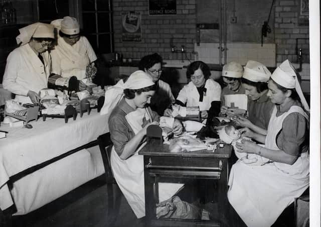 Nurses of the West Kensington ARP at Fulham in London, busy fitting out dolls' beds and dressing the dolls, during World War Two. Picture: Hulton Archive/Getty Images