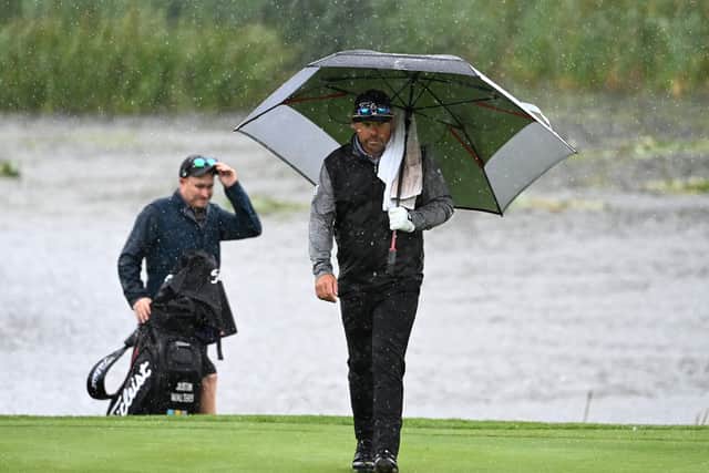 Justin Walters walks on to the 18th green amid a deluge at The Belfry. Picture: Ross Kinnaird/Getty