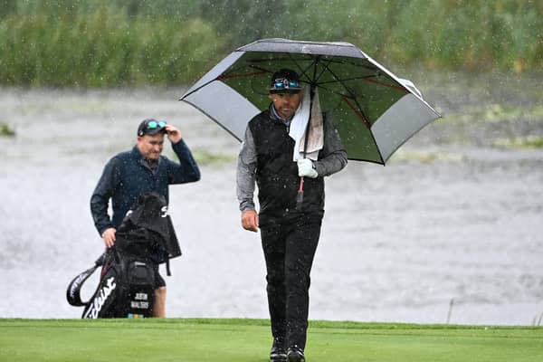 Justin Walters walks on to the 18th green amid a deluge at The Belfry. Picture: Ross Kinnaird/Getty