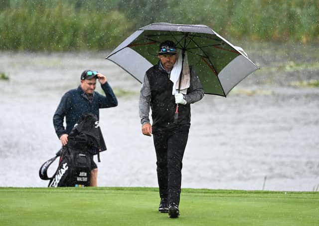 Justin Walters walks on to the 18th green amid a deluge at The Belfry. Picture: Ross Kinnaird/Getty