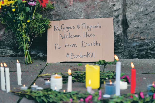People leave flowers and candles in the street opposite the UK Visa and Immigration office in Brand Street, Glasgow.
