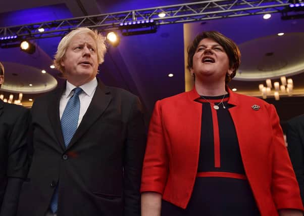DUP leader Arlene Foster (left) and now Prime Minister Boris Johnson sing God Save The Queen during the Democratic Unionist Party annual conference at the Crown Plaza Hotel in Belfast in 2018. Picture: Charles McQuillan/Getty Images