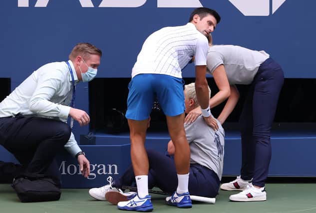 Novak Djokovic tends to a line judge who was hit with the ball during his fourth round match against Pablo Carreno Busta at the US Open. Picture: Al Bello/Getty Images