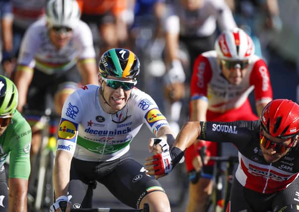 Second-placed Caleb Ewan, right, reaches out to congratulate stage winner Sam Bennett at the line. Picture: Christophe Ena/AP