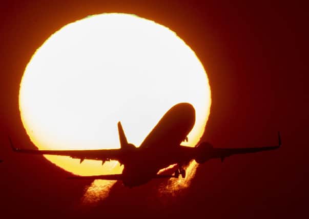 An aircraft takes off at the airport in Frankfurt, Germany, as the sun rises. Picture: AP Photo/Michael Probst