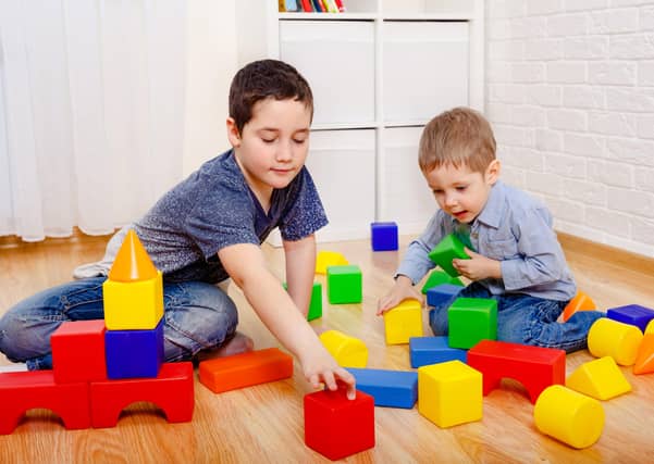 Children play with constructor blocks on the floor at home