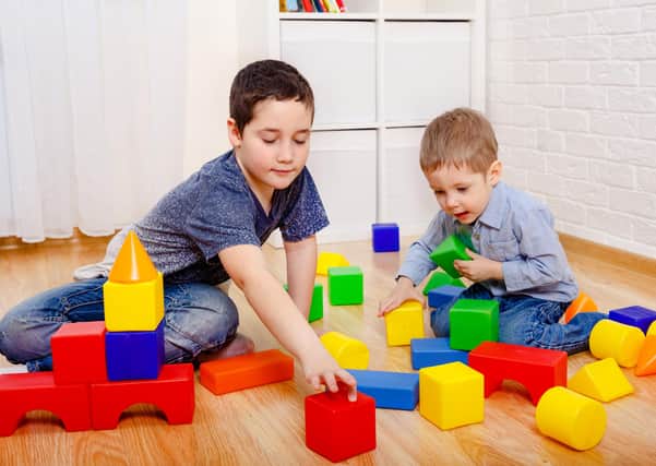 Children play with constructor blocks on the floor at home