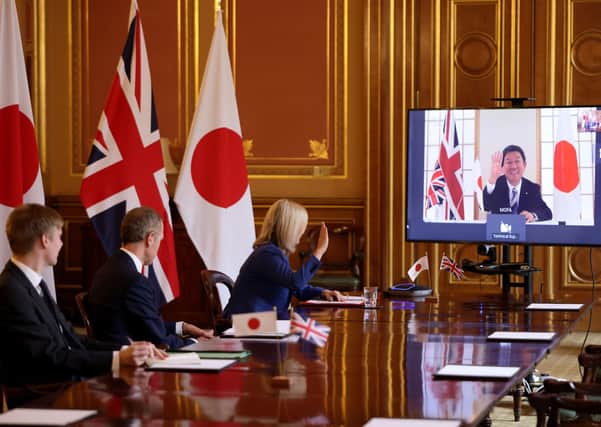 International Trade Secretary Liz Truss speaking to Japan's Minister for Foreign Affairs Toshimitsu Motegi as the UK secures a free trade agreement with Japan
