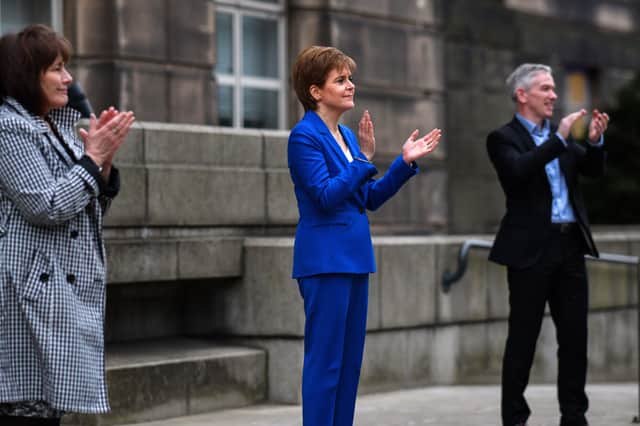 EDINBURGH, SCOTLAND - APRIL 16: First Minister Nicola Sturgeon shows her appreciation during the weekly tribute thanks to NHS and key workers throughout the coronavirus outbreak, along with Interim Chief Medical officer Gregor Smith (R) Health Secretary Jeane Freeman and Malcolm Wright Director-General for Health and Social Care and Chief Executive of NHS Scotland at St Andrews House on April 16, 2020 in Edinburgh, United Kingdom. Following the success of the "Clap for Our Carers" campaign, members of the public are being encouraged to applaud NHS staff and other key workers from their homes at 8pm every Thursday. The Coronavirus (COVID-19) pandemic has infected over 2 million people across the world, claiming at least 13,729 lives in the U.K. (Photo by Jeff J Mitchell/Getty Images)