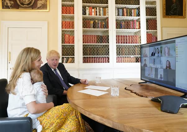 The Prime Minister Boris Johnson and his partner Carrie Symonds with their son Wilfred in the study of No10 Downing Street speaking via zoom to the midwifes that helped deliver their son
