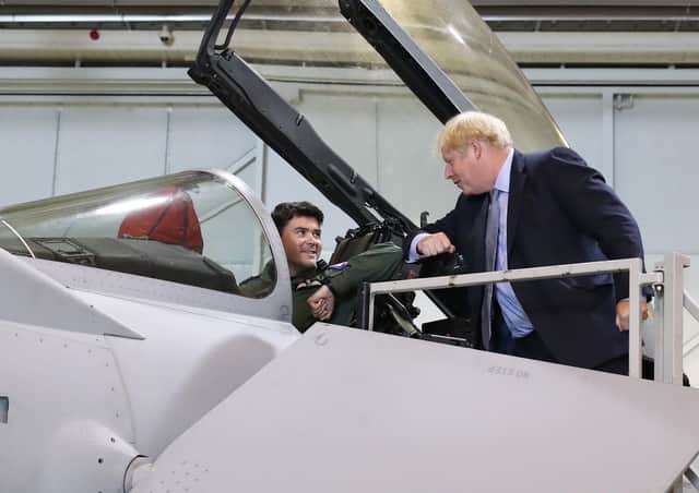 Prime Minister Boris Johnson speaks to a pilot sitting inside a Typhoon fighter jet at RAF Lossiemouth, Moray. Picture: Andrew Milligan/PA Wire