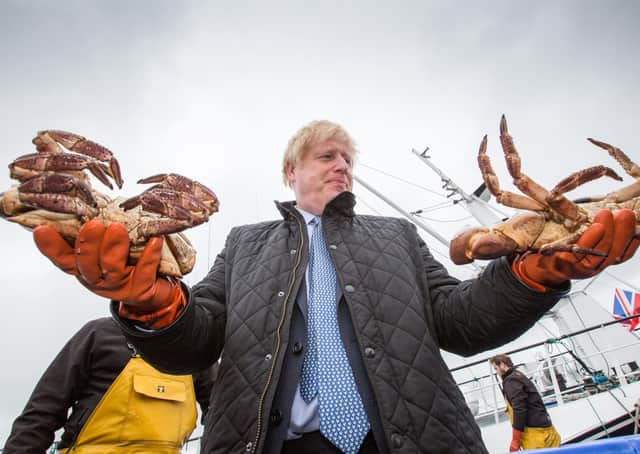 Prime Minister Boris Johnson holds crabs caught on the Carvela at Stromness Harbour in Stromness during a visit to Scotland today. Picture: Robert Perry/PA Wire
