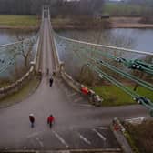 Members of the public cross the Union Bridge on the River Tweed