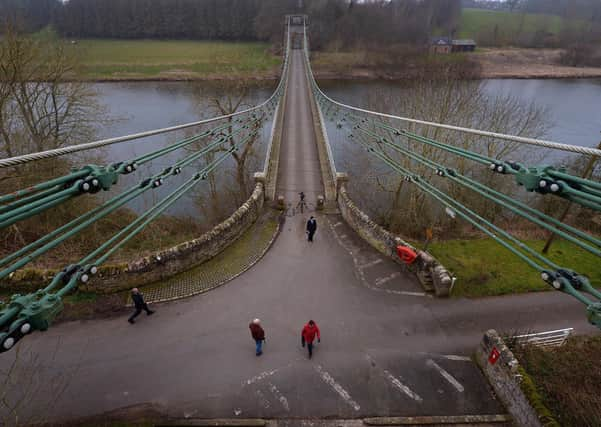 Members of the public cross the Union Bridge on the River Tweed