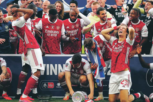 Pierre-Emerick Aubameyang, left, drops the FA Cup during the presentation ceremony. Picture: Catherine Ivill/Getty Images