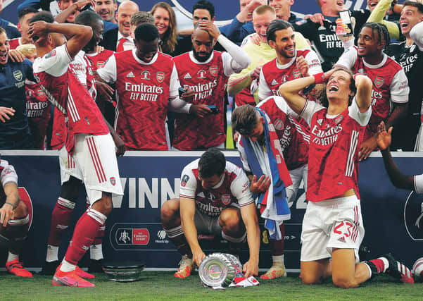 Pierre-Emerick Aubameyang, left, drops the FA Cup during the presentation ceremony. Picture: Catherine Ivill/Getty Images