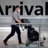 A passenger wearing a face mask as a precaution against the novel coronavirus arrives at Heathrow airport