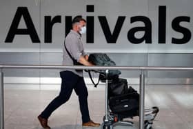 A passenger wearing a face mask as a precaution against the novel coronavirus arrives at Heathrow airport
