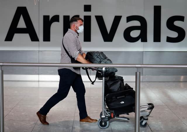 A passenger wearing a face mask as a precaution against the novel coronavirus arrives at Heathrow airport