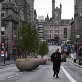 A pedestrian walks on an empty street in Aberdeen