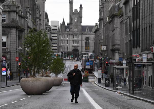 A pedestrian walks on an empty street in Aberdeen