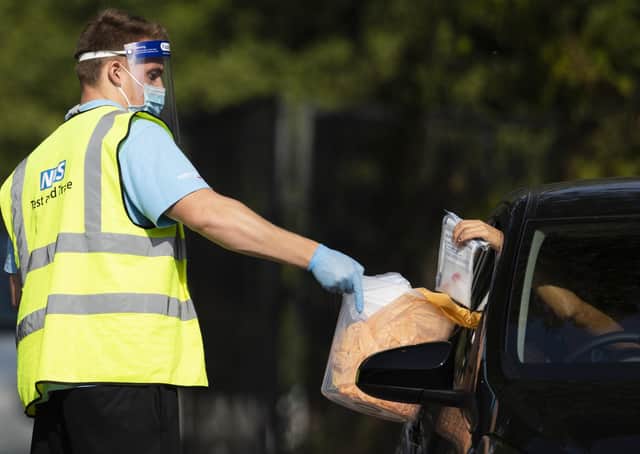 A worker collects a swab test from a member of the public at a Covid test site (Picture: Dan Kitwood/Getty Images)