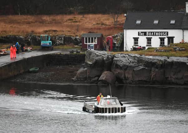 The ferry heads out across the Sound of Ulva with The Boathouse restaurant in the background (Picture: SWNS)