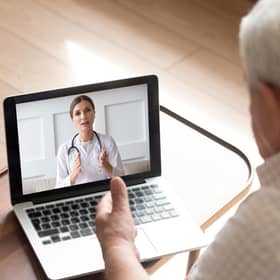An older man talks with a doctor by video call