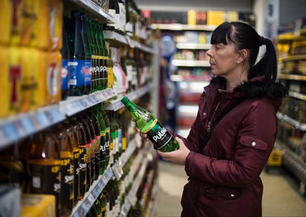A shopper considers buying a bottle of cider. Picture: John Devlin