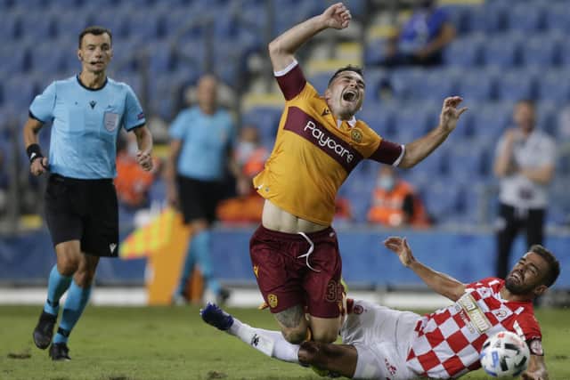 Motherwell forward Tony Watt is tackled by Hapoel's opening scorer Miguel Vitor. Picture: Ariel Schalit/AP