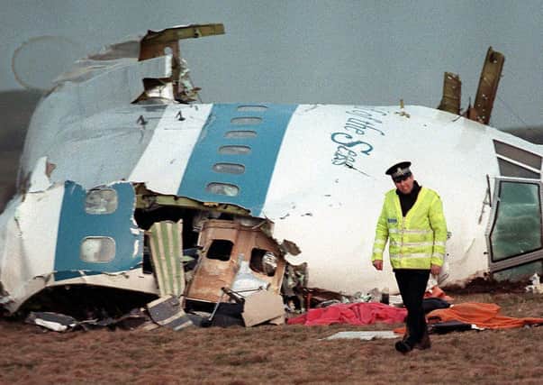 A policeman walking nearby the cockpit of the 747 Pan Am Boeing that exploded, killing all 259 on board and 11 on the ground.