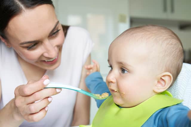 An eight-month-old baby is spoon fed