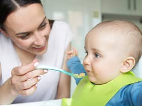 An eight-month-old baby is spoon fed