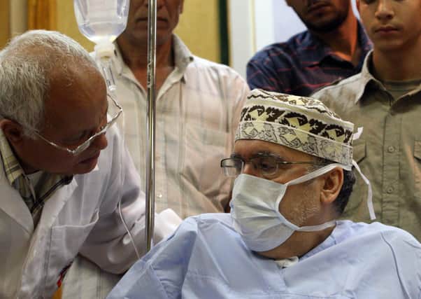 Freed Lockerbie bomber Abdelbaset Ali Mohmet al-Megrahi speaks to a doctor  at a hospital in Tripoli on September 9, 2009.