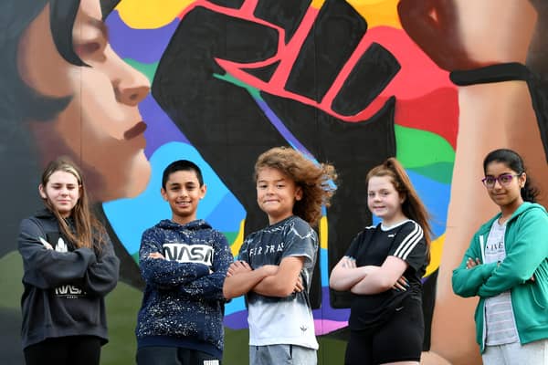 Members of the Govanhill Youth Group in front of the new mural they helped design.
.