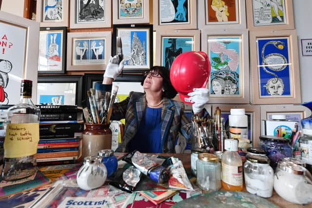 TV auctioneer Anita Manning at Great Western Auctions, Glasgow, Scotland, admires some of the contents of her friend Scottish writer and painter Alasdair Gray's studio