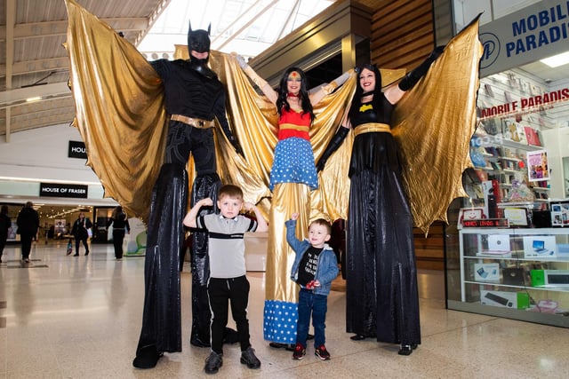 Batman, Batgirl and Wonder Woman using their powers to keep their balance.