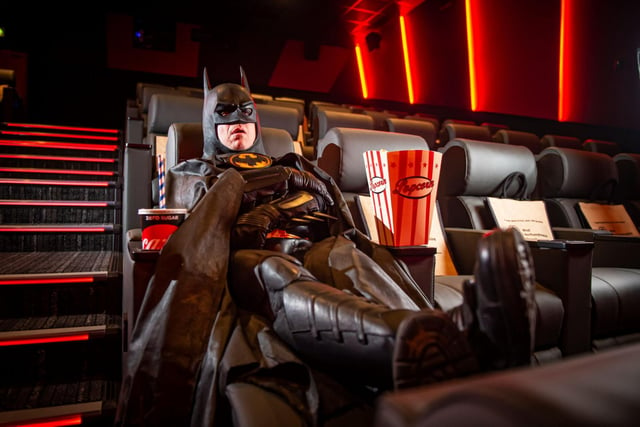 Batman tucks into his popcorn to watch the movie