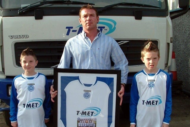 THANKS T-MET...East End Youth F.C Under 10`s captain Adam Harte and Striker Jamie Ellis hand over a framed and mounted team shirt to James from T-Met Coleraine who have sponsored the team's new away kit for the season. The Under 10`s play in the Down and Connor League in Mallusk and hope this sponsorship with the kit sponsors of Portadown F.C. will bring them success in the future. CR41042s