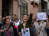 Nasibe Samsaei, an Iranian woman living in Turkey, holds up her ponytail after cutting it off during a protest outside the Iranian consulate in Istanbul (Picture: Yasin Akgul/AFP via Getty Images)