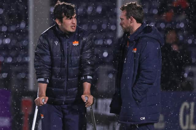 Edinburgh hooker Stuart McInally in crutches at the end of the game as he speaks to coach Mike Blair. (Photo by Craig Williamson / SNS Group)